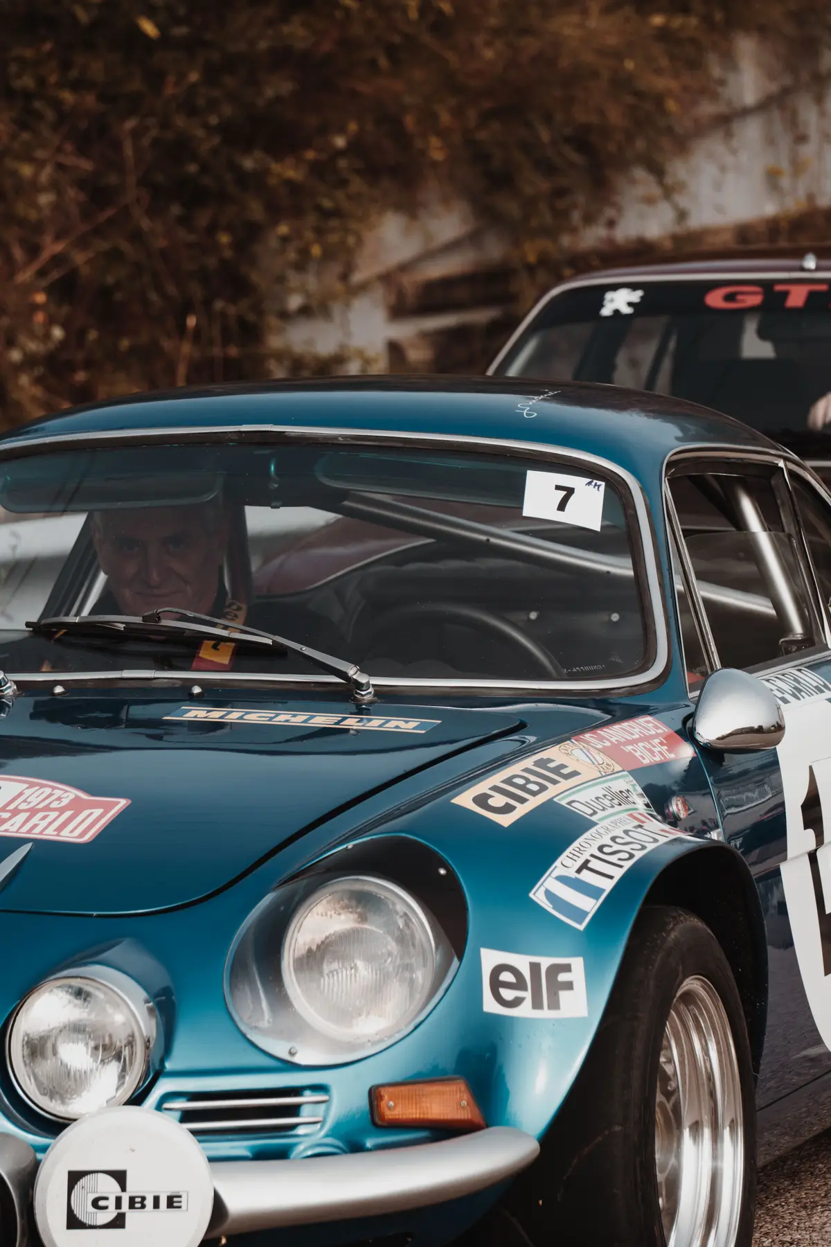 Pilote au volant d’une Porsche 911 de rallye, vu à travers le pare-brise