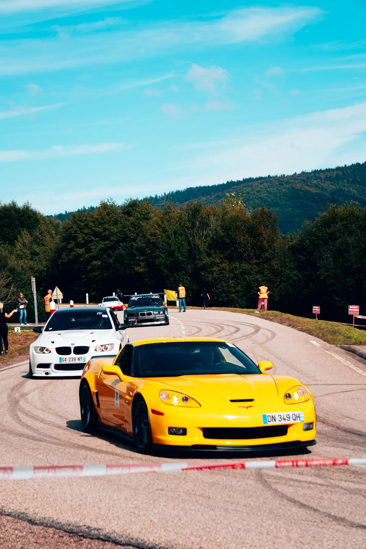 File de voitures de sport à l’entrée d’un virage de montagne