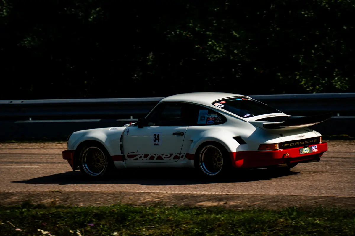 Porsche 911 Carrera RSR blanche de profil, lancée sur l’asphalte