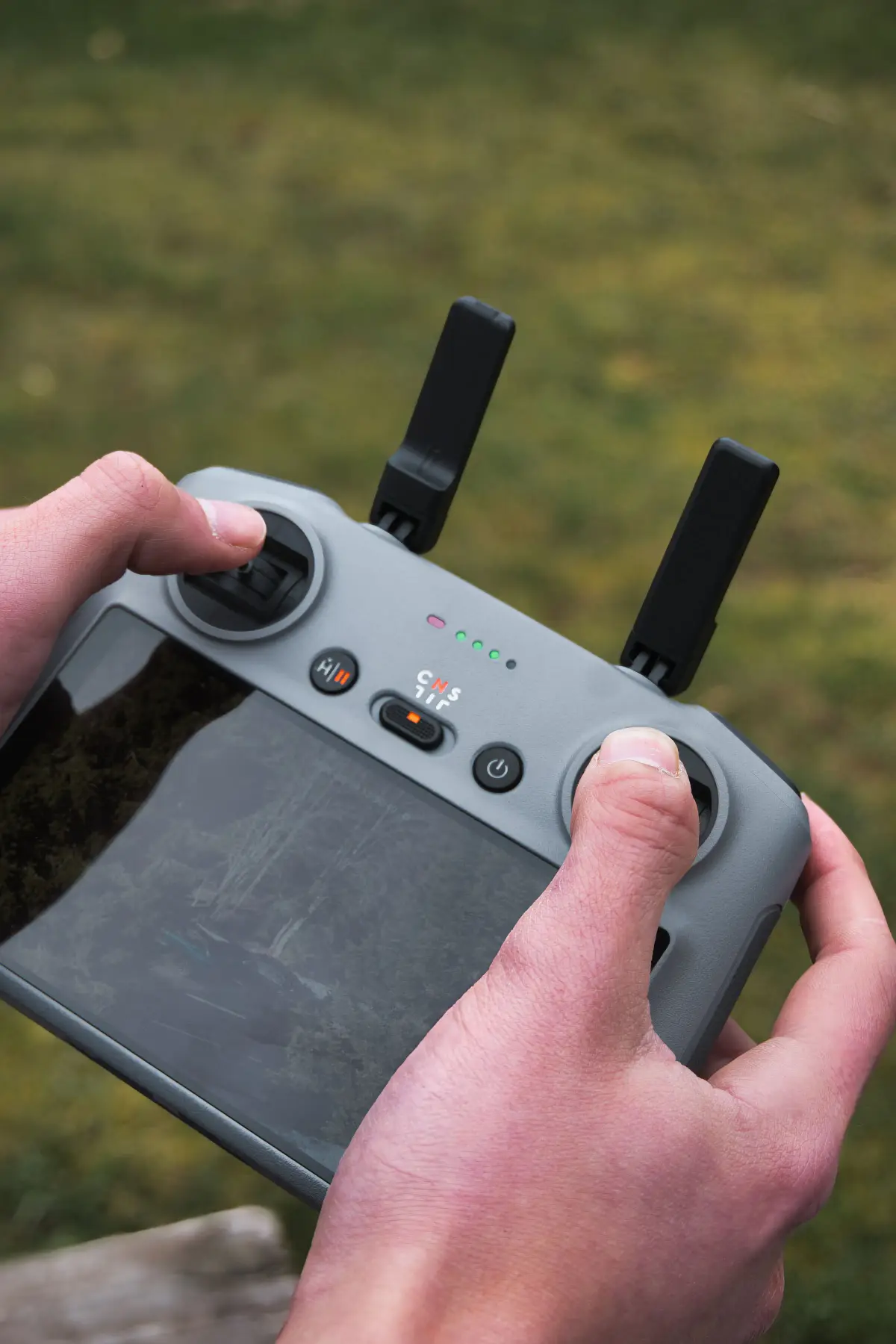 Radiocommande de drone en main pendant un vol