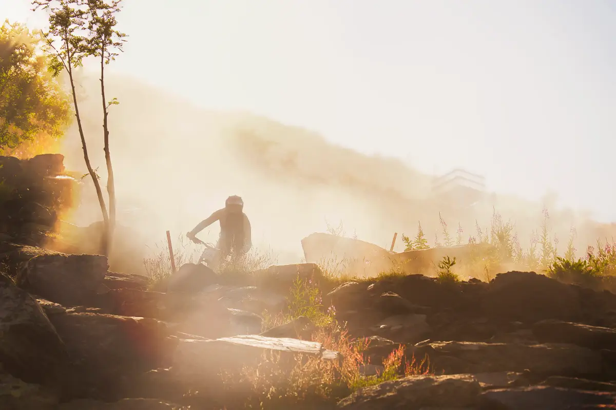 Silhouette d’un coureur dans la poussière, à contre-jour