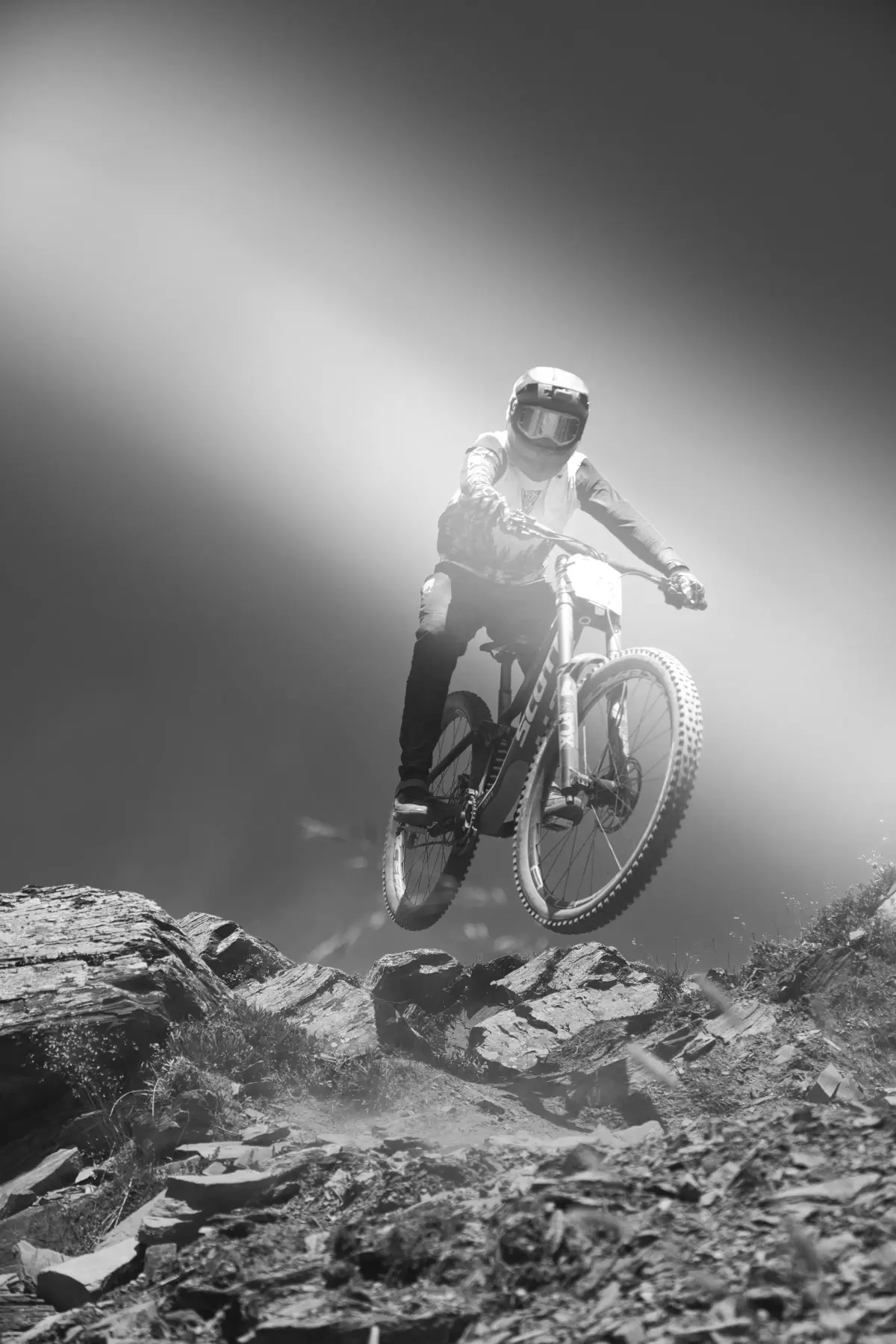 Vététiste en noir et blanc sur un sentier forestier